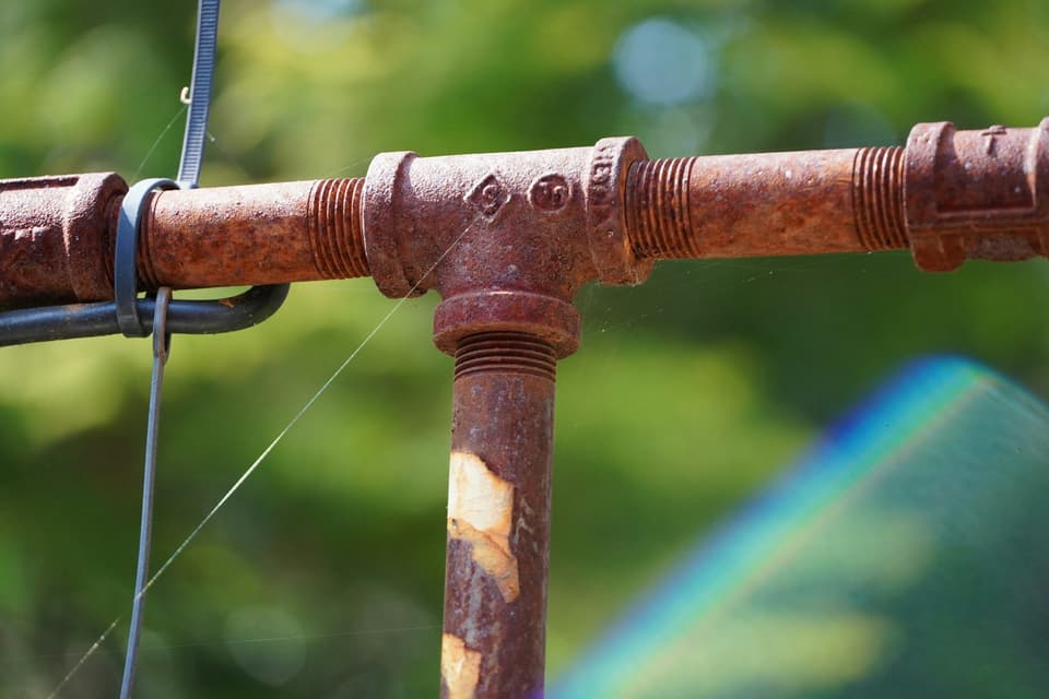Rusted threaded steel pipe joined at a tee fitting